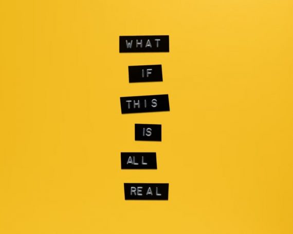 Inspirational text 'What if this is all real' on yellow surface.